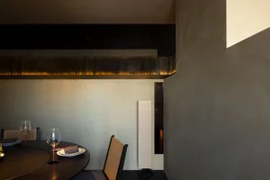 Empty dining area with a wooden table and chairs, a wine glass, and an inviting atmosphere