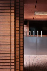 A casual bar area with a brick wall, featuring multiple beer taps and a rustic atmosphere