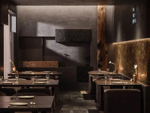 Dark and moody restaurant interior with tables and chairs, wine glasses, and industrial design elements