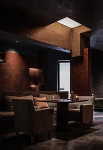 A modern living space with a dining table, two couches, and decorative elements, creating a cozy atmosphere