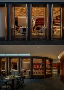 Inviting open kitchen with dining area, chairs, and bottles on display, set against a warm and comfortable atmosphere