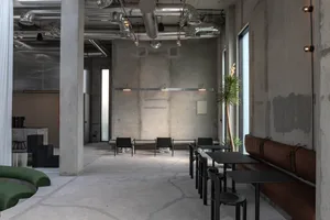 Empty restaurant interior with concrete walls, floors, and furniture, featuring a minimalist and modern atmosphere