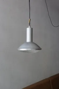 A modern room with a unique lamp hanging from the ceiling, surrounded by clean and minimalistic space with a focus on functionality