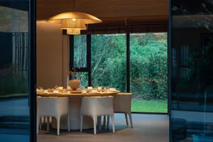 A modern dining space with a round table, white chairs, and various decorative items, creating a welcoming atmosphere