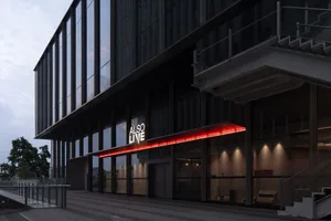 A modern building with glass windows, a red sign, and a contemporary design