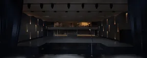 Large empty auditorium with a stage and chairs placed around the area, creating a sense of openness and space for performances or gatherings