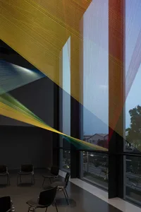 A colorful interior space with strings hanging from windows, chairs, and a lively atmosphere