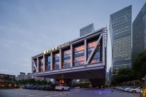 A modern hotel lobby with a prominent glass facade, multiple floors, and a contemporary design