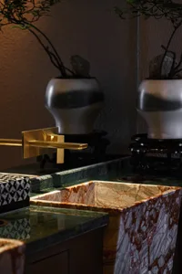Bathroom with a sink, vases, and a potted plant, featuring a clean and organized atmosphere