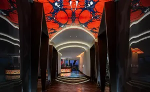 Ornate lobby with a red ceiling design, marble countertop, and a modern luxurious feel