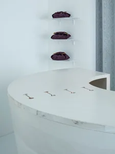 A bathroom with a wooden countertop, three hanging shelves, and various items placed on the countertop, creating an organized and functional space