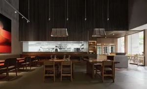 Warm and inviting restaurant kitchen with wooden tables and chairs, wine glasses, and a focus on functionality and comfort