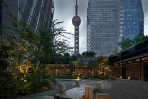 A modern building with a glass facade, surrounded by trees, creating a calm and inviting atmosphere