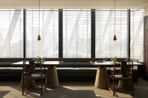 Bright modern restaurant interior with natural light, dining tables, and chairs