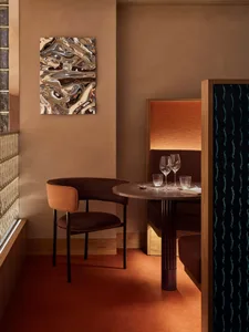 Warm and inviting dining space with a wooden table, chairs, and wine glasses, set in a restaurant