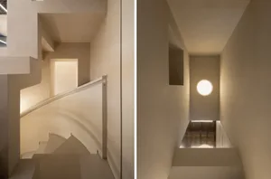 A minimalist staircase with a white color scheme, featuring a curved spiral design and a straight flight of steps, showcasing the clean and elegant design of the stairwell