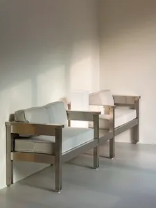 Two single beds in a calm and inviting white room with pillows and no other objects or people
