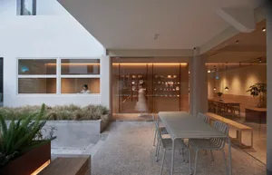 A cozy restaurant dining area with a wooden table and chairs, surrounded by a counter for ordering, creating a warm and inviting atmosphere for social interaction and relaxation