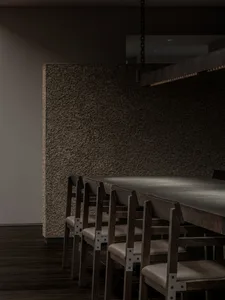 A warm and inviting dining area with a large wooden table surrounded by chairs, creating a welcoming space for guests to gather and enjoy meals together