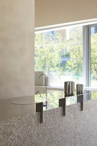 A clean and organized kitchen with a focus on functionality and practicality, featuring a sink, countertop, and various items on display