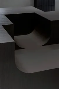A dark wooden table with two curved benches forming an L shape, creating a cozy and intimate atmosphere