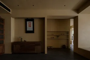 Empty living room with a wooden cabinet, vases, and potted plants, featuring a clean and minimalist aesthetic