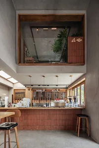 Cozy cafe with a wooden countertop, chairs, stools, and multiple cups, creating a warm and inviting atmosphere