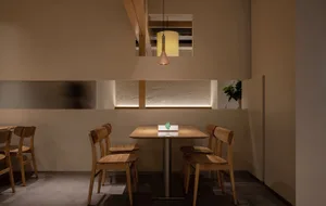 Warm and inviting restaurant interior with two tables, four chairs, and potted plants