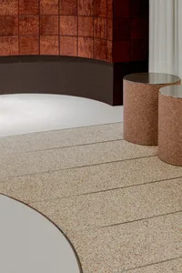 Two round marble tables in a modern hallway with sophisticated lighting creating a warm and inviting atmosphere