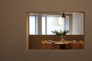 A well-lit dining area with two tables and chairs, a vase, and elegant ambiance