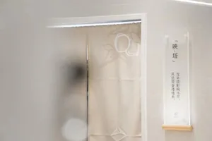 A bathroom with a patterned shower curtain, two people enjoying a calm atmosphere