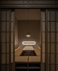 Dimly lit dining room with a symmetrical arrangement of chairs around a wooden table, creating a cozy atmosphere