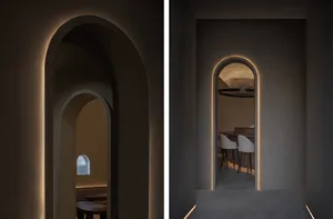 Dimly lit restaurant with stone walls, chairs, and dining tables