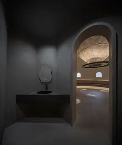 A modern bathroom with two sinks, a large mirror above one sink, a smaller mirror on the right, and a toilet near the right wall