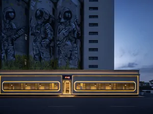 A building facade featuring two large paintings of men in spacesuits above a doorway, with a futuristic and creative atmosphere