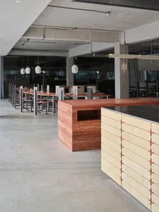 Dining space with a wooden countertop island, chairs, and tables in a spacious and inviting restaurant setting