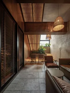 Open living area with a large window, two chairs, and a couch, featuring modern design and natural light