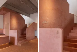 A modern interior space with a staircase featuring wooden and concrete steps in a brown color scheme, set against a neutral background
