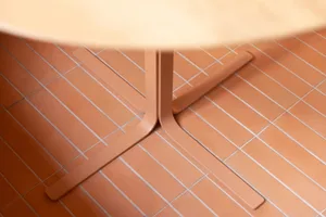 A wooden dining table sits on a patterned tile floor in a warm and inviting room, perfect for gatherings and meals