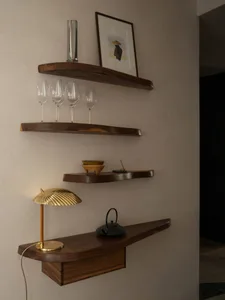 A wooden table in a cozy bar setting with wine glasses, a bowl, and a handbag, suggesting a relaxed social gathering