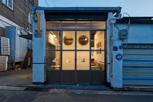 A small, well-lit room with two dining tables and chairs, creating an inviting and organized atmosphere