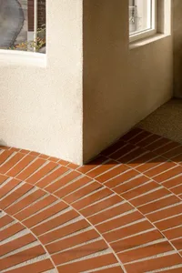 A traditional building exterior featuring a brick wall with a window, providing natural light and ventilation