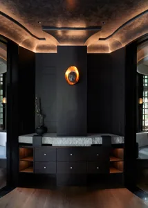 Modern living room with a wooden cabinet, two chairs, and a vase, featuring a sophisticated ambiance