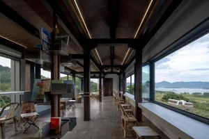 Open restaurant interior with wooden floors and walls, warm atmosphere, and multiple chairs and tables