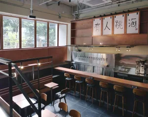 A warm and inviting bar area with a long wooden counter and multiple chairs, set in a restaurant