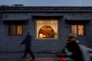 A brick restaurant with a dining table and chairs inside, surrounded by a cozy atmosphere and a potted plant