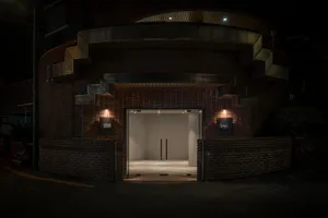 Spacious entrance with brick walls, modern doors, and an inviting archway leading to a warm and rustic interior