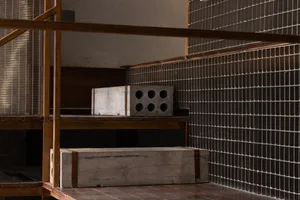 Old building with a staircase and two large concrete blocks near the entrance, suggesting a renovation project with a mix of industrial and historical elements