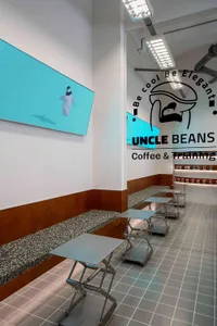 A modern coffee shop with brown and white walls, benches, and a large TV mounted on the wall, creating a warm and inviting atmosphere