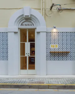 A white door with two handles, open and flanked by two signs, in a welcoming and inviting atmosphere